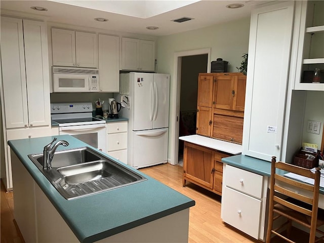 7 Hyde Ave, Jekyll Island, GA 31527 - kitchen with white appliances, light wood-style floors, a sink, an island with sink, and recessed lighting