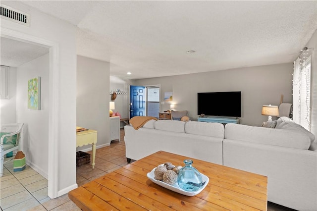 living room with light tile patterned flooring and a textured ceiling