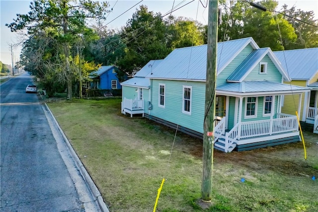 view of home's exterior featuring covered porch and a yard