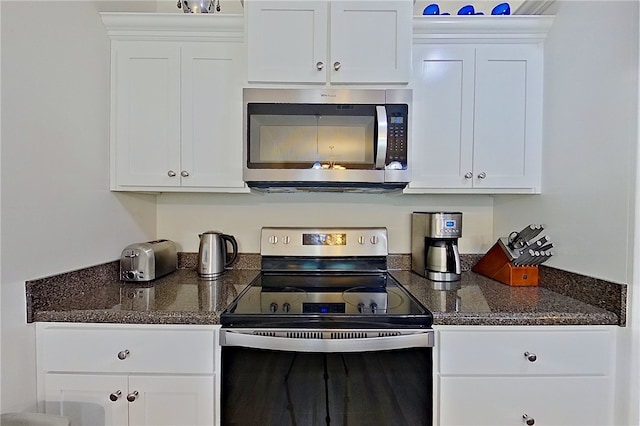288 Bridgewater Ln, Darien, GA 31305 - kitchen with stainless steel appliances, white cabinetry, and dark stone countertops
