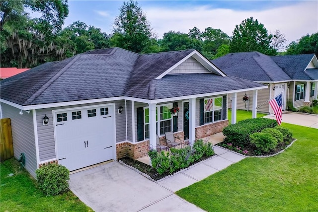 288 Bridgewater Ln, Darien, GA 31305 - view of front of house featuring a porch, driveway, a garage, a shingled roof, and brick siding