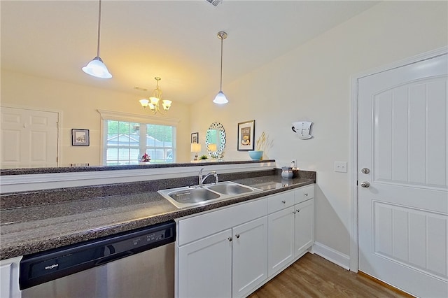288 Bridgewater Ln, Darien, GA 31305 - kitchen with stainless steel dishwasher, dark countertops, a chandelier, and dark wood-type flooring