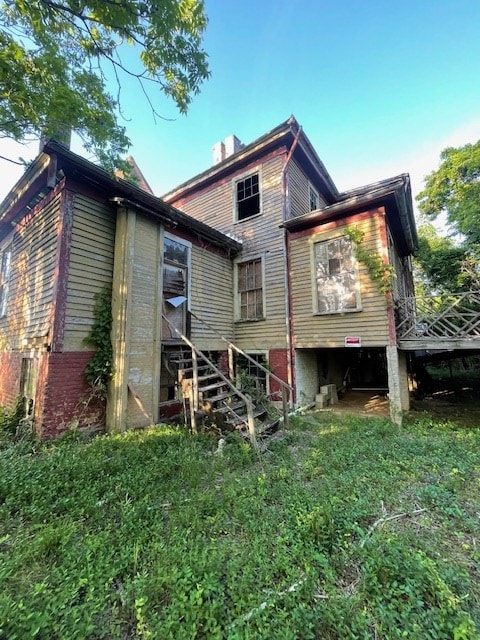 rear view of house with stairway and a chimney