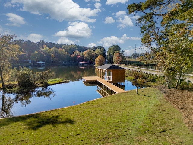 view of dock with a yard and a water view