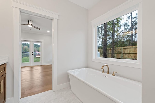 bathroom featuring a bathtub, ceiling fan, vanity, and french doors