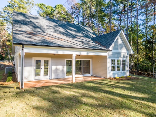 back of property with ceiling fan, a yard, french doors, central AC unit, and a patio area