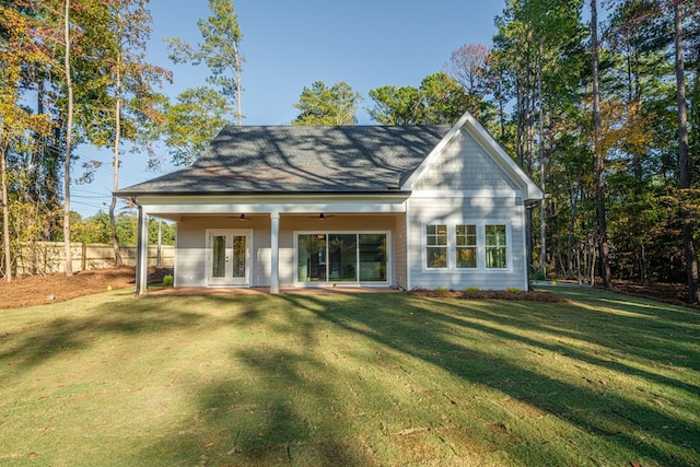 rear view of house with ceiling fan, a yard, and french doors