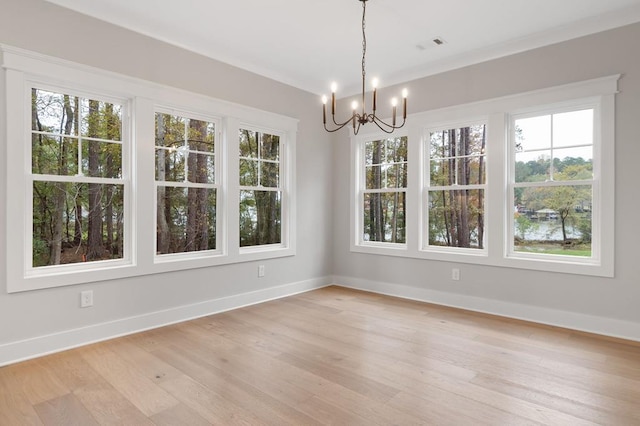 unfurnished dining area with a notable chandelier, light hardwood / wood-style floors, and plenty of natural light