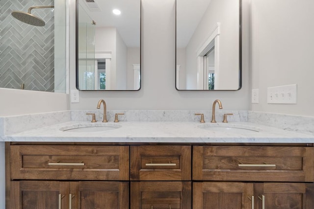 bathroom with tiled shower and vanity