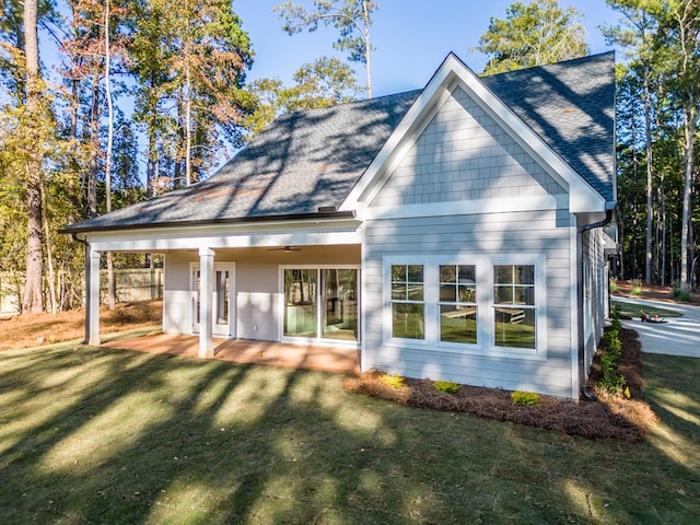 rear view of property featuring a lawn