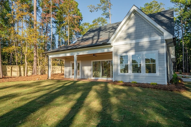 back of house featuring ceiling fan and a lawn