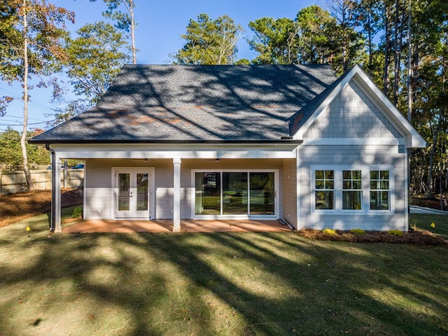 rear view of house with a lawn and french doors