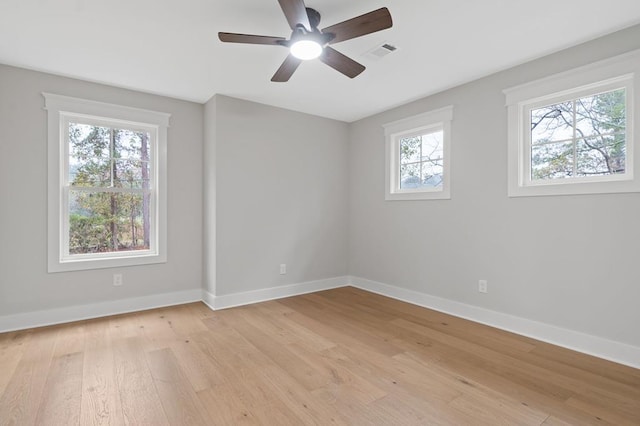 unfurnished room with a wealth of natural light, light hardwood / wood-style flooring, and ceiling fan