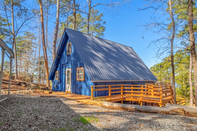 view of side of home featuring metal roof and a wooden deck