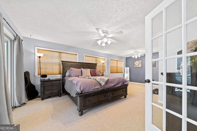 carpeted bedroom with a textured ceiling, baseboards, a ceiling fan, and french doors
