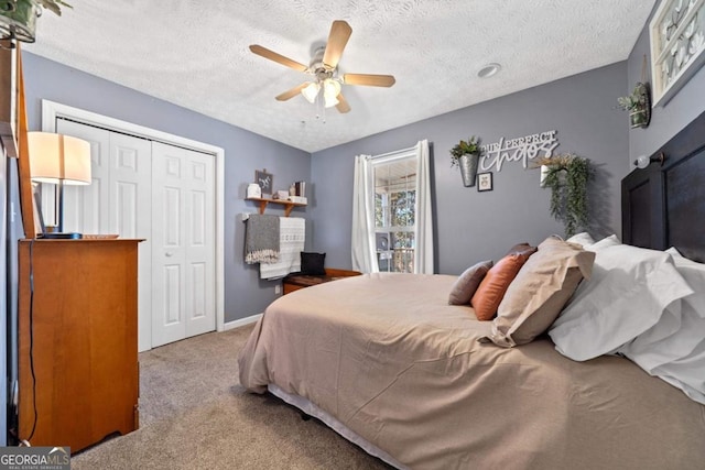 bedroom featuring a closet, a textured ceiling, carpet, baseboards, and ceiling fan