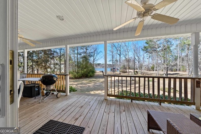 deck featuring a water view, a grill, and a ceiling fan