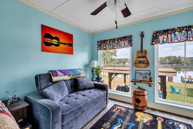 sitting room featuring a water view, crown molding, and a wealth of natural light