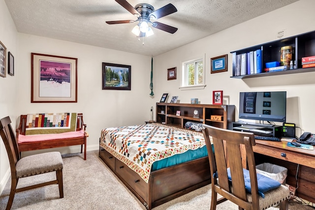 bedroom with a textured ceiling, light colored carpet, and ceiling fan