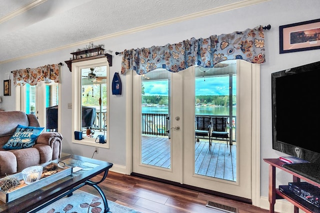 doorway with french doors, dark hardwood / wood-style flooring, a textured ceiling, ceiling fan, and crown molding