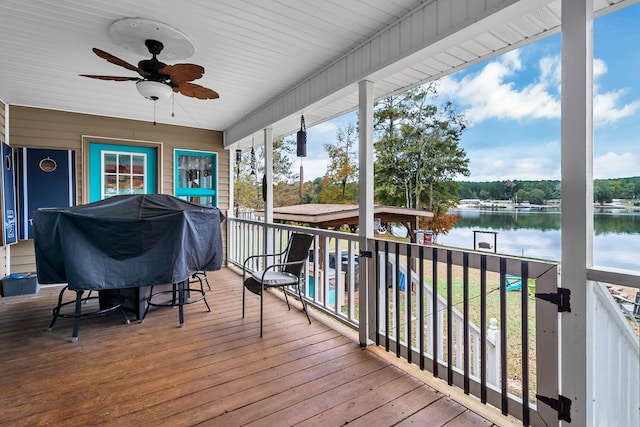 sunroom with ceiling fan and a water view