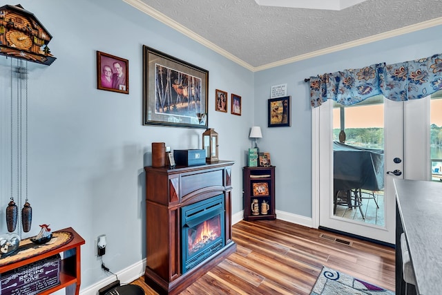 sitting room featuring crown molding, wood-type flooring, and a textured ceiling