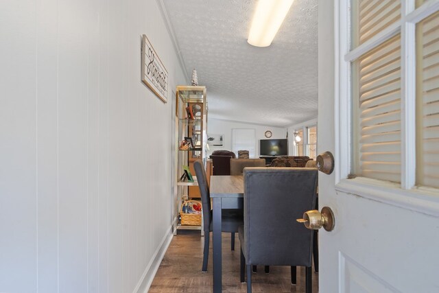 dining space with a textured ceiling and wood finished floors