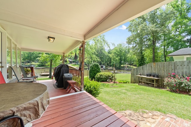 wooden deck with view of wooded area and area for grilling
