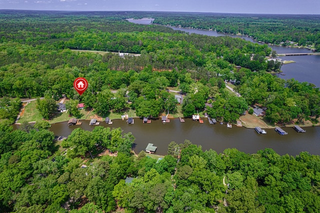 view of property location with a heavily wooded area and a nearby body of water
