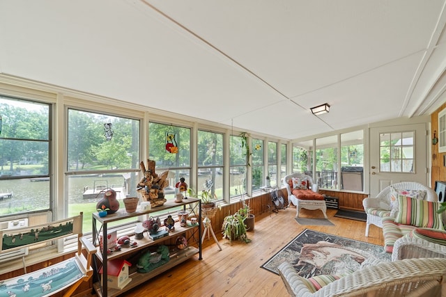sunroom with wood-type flooring and vaulted ceiling