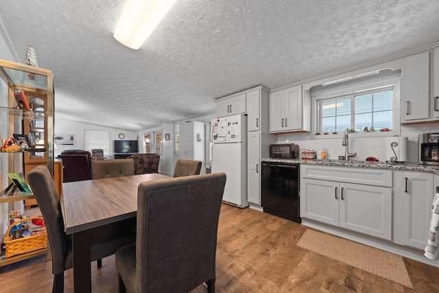 kitchen with dishwasher, freestanding refrigerator, a textured ceiling, light wood finished floors, and a sink