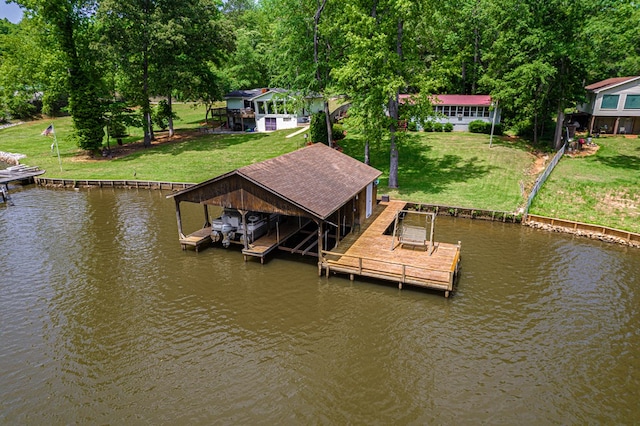 dock featuring a water view, boat lift, and a lawn
