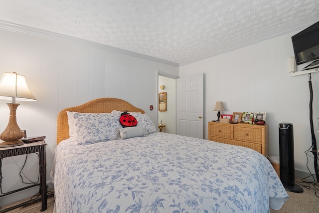 bedroom featuring carpet flooring, ornamental molding, and a textured ceiling
