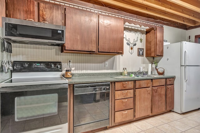 kitchen featuring black dishwasher, range with electric cooktop, stainless steel microwave, brown cabinets, and freestanding refrigerator