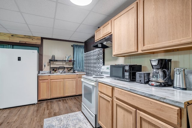 kitchen with white appliances, under cabinet range hood, light countertops, and light brown cabinetry