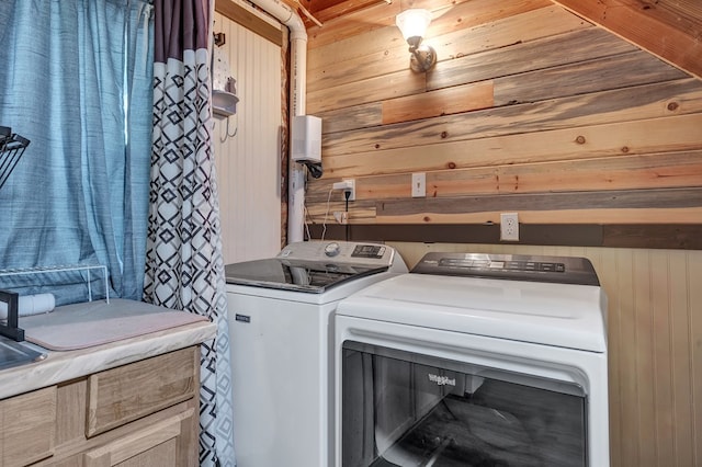 laundry room with laundry area, independent washer and dryer, and wood walls