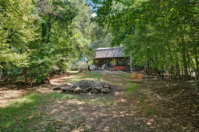 view of yard featuring a forest view and an outdoor fire pit