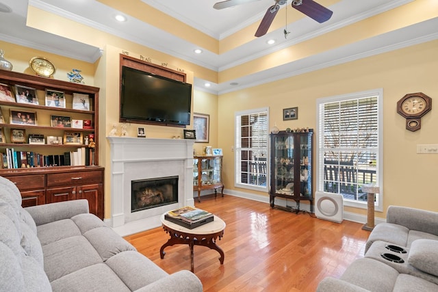 living room with ornamental molding, a healthy amount of sunlight, and light wood-style flooring