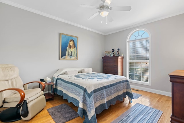 bedroom with ornamental molding, light wood-style flooring, baseboards, and a ceiling fan