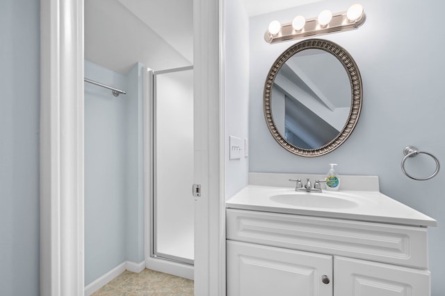 full bath featuring a stall shower, vanity, and baseboards