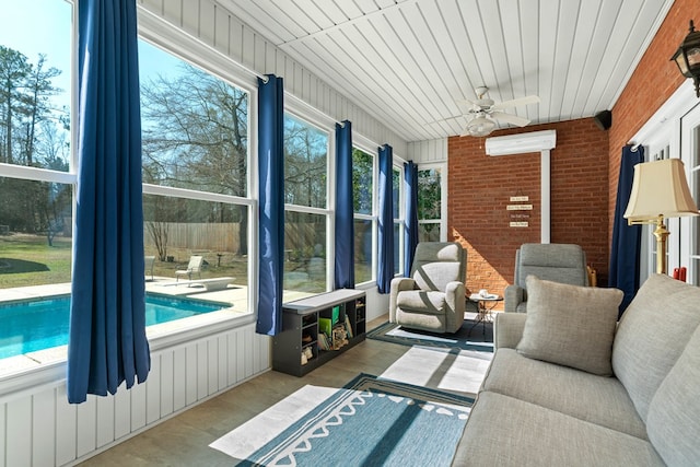 sunroom / solarium with a wall unit AC and a ceiling fan