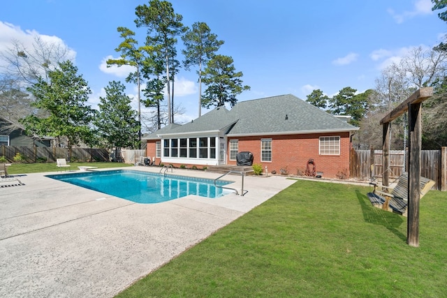 view of swimming pool with a fenced in pool, a yard, a patio, a sunroom, and a fenced backyard