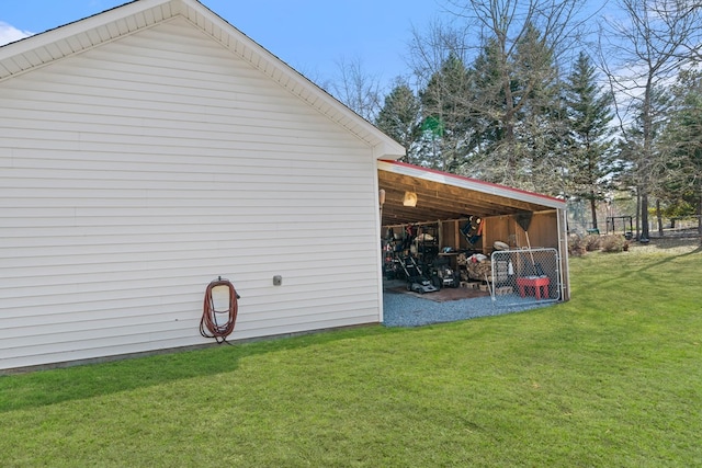 view of side of home with a carport, an outbuilding, and a lawn