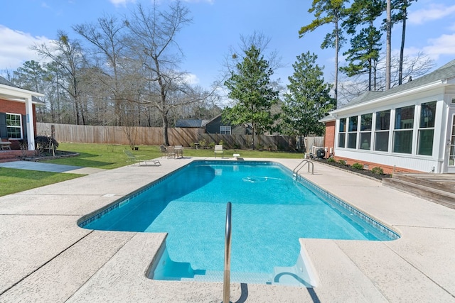 view of swimming pool featuring a patio area, a fenced backyard, and a lawn