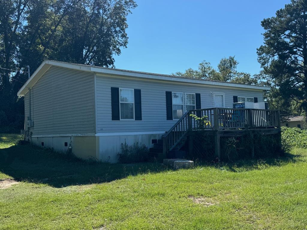 manufactured / mobile home with a deck and a front lawn