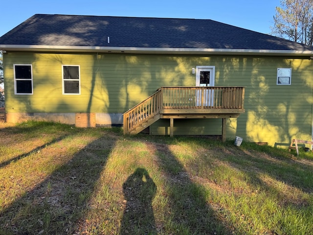 rear view of property with a wooden deck and a yard