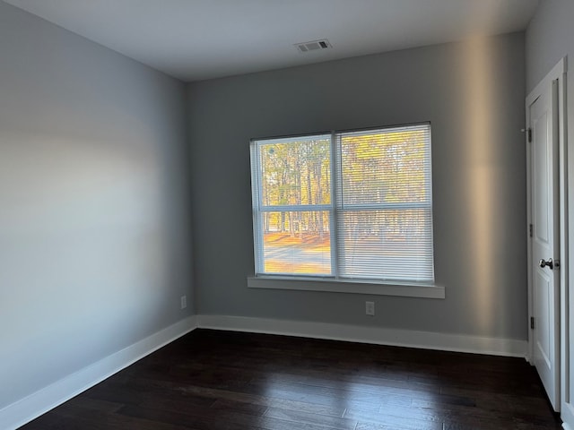 unfurnished room with dark hardwood / wood-style flooring