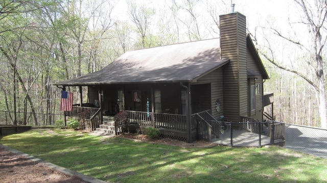 102 Treanor Dr, Milledgeville, GA 31061 - view of front facade with covered porch, a chimney, fence, and a front yard
