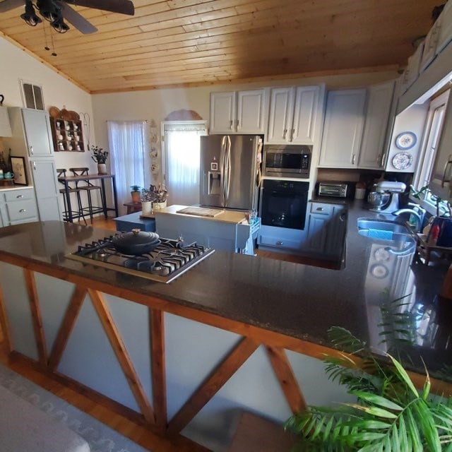 102 Treanor Dr, Milledgeville, GA 31061 - kitchen with stainless steel appliances, wood ceiling, dark countertops, a sink, and ceiling fan