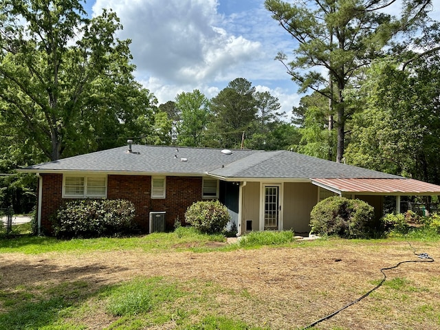 view of front of house with central AC and a shingled roof